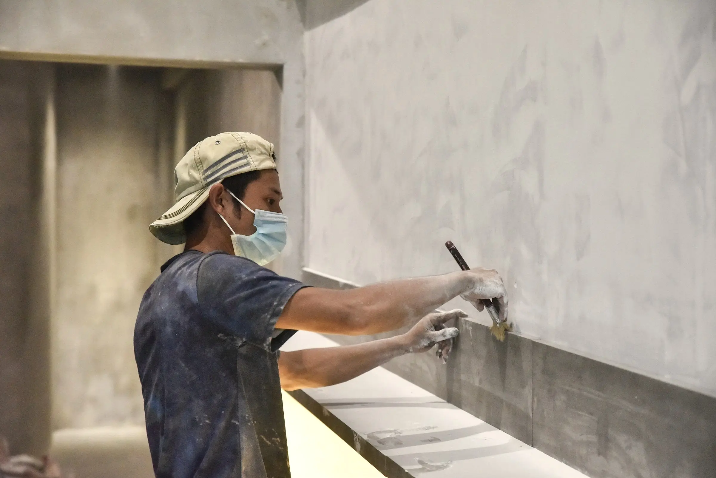Operario alisando la superficie de una pared antes de pintar